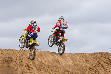 Image showing Volgograd, Russia - April 19, 2015: Two motorcycle racer climb onto the next obstacle on the stage of the Open Championship Motorcycle Cross Country Cup Volgograd Region Governor