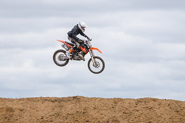 Image showing Volgograd, Russia - April 19, 2015: Motorcycle racer jumped above the ground on the springboard, at a stage of the open championship motorcycling Cup cross-country Volgograd Region Governor