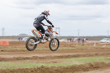 Image showing Volgograd, Russia - April 19, 2015: Motorcycle racer in flight after the jump through the trampoline at the stage of the open championship motorcycling Cup cross-country Volgograd Region Governor