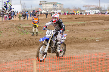 Image showing Volgograd, Russia - April 19, 2015: Motorcycle racer racing on the track, the spectators in the background, at the stage of the Open Championship Motorcycle Cross Country Cup Volgograd Region Governor