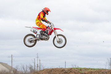 Image showing Volgograd, Russia - April 19, 2015: Motorcycle racer jumping on the trampoline in flight, at the stage of the Open Championship Motorcycle Cross Country Cup Volgograd Region Governor