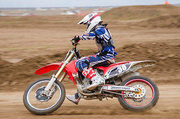 Image showing Volgograd, Russia - April 19, 2015: Motorcycle racer rides on the road getting ready to make a turn on the stage of the Open Championship Motorcycle Cross Country Cup Volgograd Region Governor