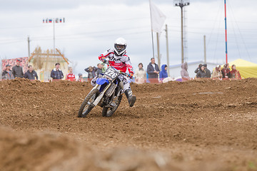 Image showing Volgograd, Russia - April 19, 2015: Motorcycle racer insured against falling outstretched leg in the corner, at the stage of the Open Championship Motorcycle Cross Country Cup Volgograd Region Governo