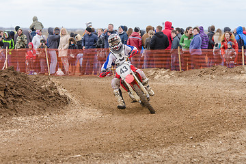 Image showing Volgograd, Russia - April 19, 2015: Motorcycle racer rides on the turn track, the spectators in the background, at the stage of the Open Championship Motorcycle Cross Country Cup Volgograd Region Gove