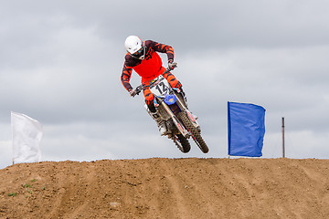 Image showing Volgograd, Russia - April 19, 2015: Motorcycle racer jumped out from behind the next hill on the road, on the stage of the Open Championship Motorcycle Cross Country Cup Volgograd Region Governor