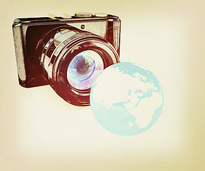 Image showing 3d illustration of photographic camera and Earth. 3D illustratio