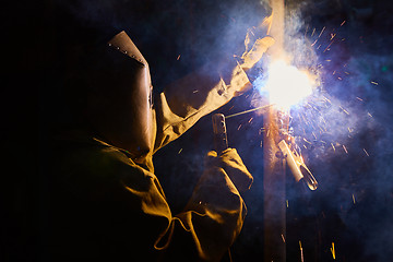 Image showing welder worker welding metal by electrode