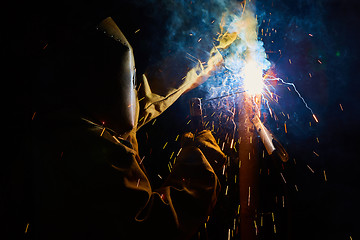 Image showing welder worker welding metal by electrode