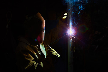 Image showing welder worker welding metal by electrode