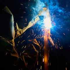 Image showing welder worker welding metal by electrode