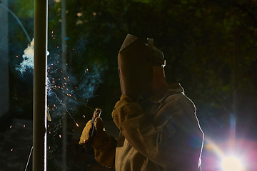 Image showing welder worker welding metal by electrode