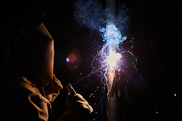 Image showing welder worker welding metal by electrode