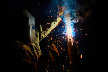 Image showing welder worker welding metal by electrode