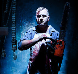 Image showing Bloody Halloween theme: crazy killer as butcher with electric saw