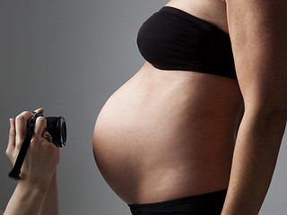 Image showing belly of a pregnant woman being photographed