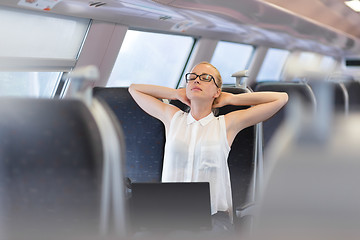 Image showing Woman streching while travelling by train.