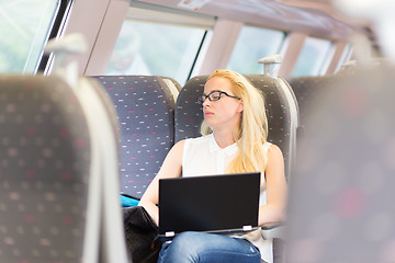 Image showing Woman sleeping while travelling by train.