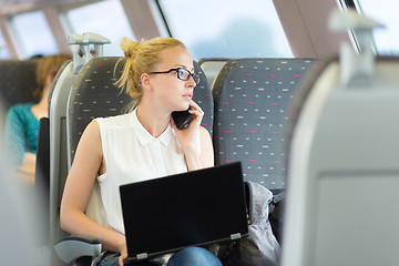 Image showing Business woman working while travelling by train.