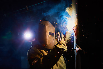 Image showing welder worker welding metal by electrode