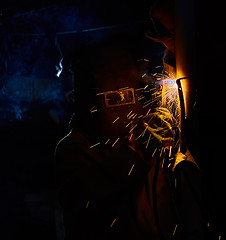 Image showing welder worker welding metal by electrode