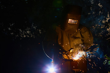 Image showing welder worker welding metal by electrode