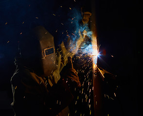 Image showing welder worker welding metal by electrode