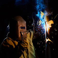 Image showing welder worker welding metal by electrode