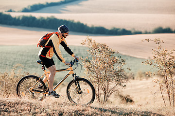 Image showing Mountain Bike cyclist riding single track above sunset valley