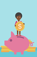 Image showing Business woman putting coin in piggy bank.