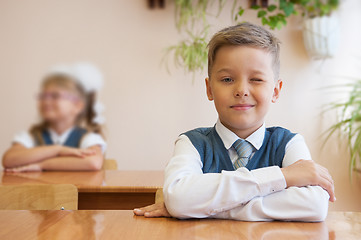 Image showing Happy schoolboy sitting at desk