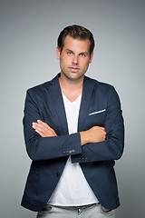 Image showing Portrait of a smart young man standing with arms crossed.