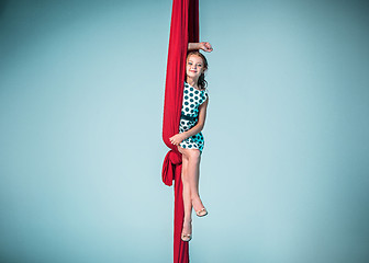 Image showing Graceful gymnast sitting with red fabrics