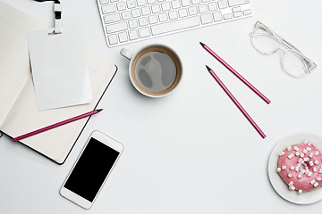 Image showing Office desk table with computer, supplies, phone and coffee cup.