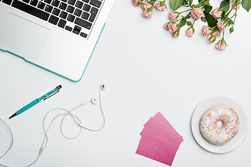 Image showing Office desk table with computer, supplies, flowers