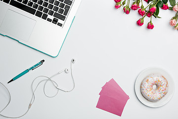 Image showing Office desk table with computer, supplies, flowers