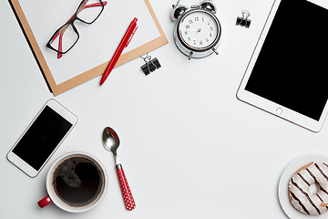 Image showing Office desk table with laptop, supplies, phone and coffee cup.