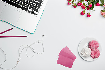 Image showing Office desk table with computer, supplies, flowers