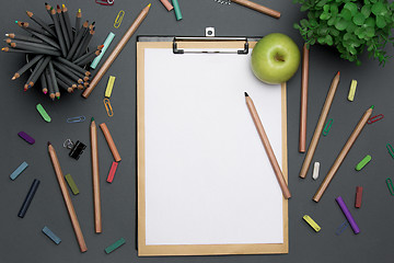 Image showing Office desk table with pencils, supplies and flowers