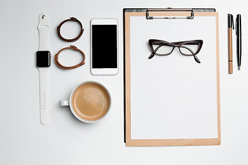 Image showing Office desk table with cup, supplies, phone on white