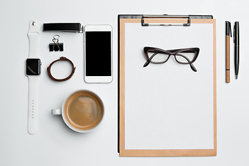 Image showing Office desk table with cup, supplies, phone on white