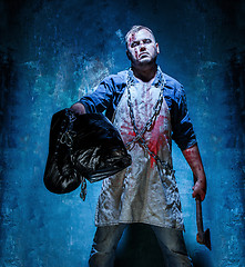 Image showing Bloody Halloween theme: crazy killer as butcher with an ax