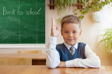 Image showing Happy schoolboy sitting at desk