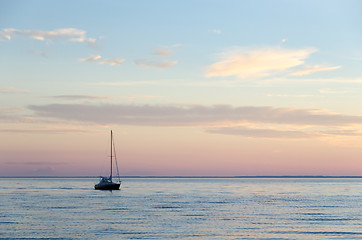 Image showing Single sailboat in calm water