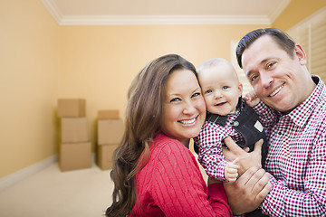 Image showing Young Family In Room With Moving Boxes