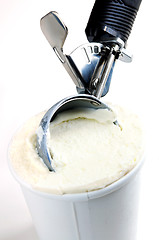 Image showing Tub of vanilla ice cream with a scoop