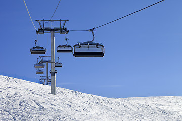 Image showing Ski-lift and off-piste slope in sun cold day