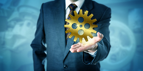 Image showing Businessman Showing One Golden Cog Wheel In Palm