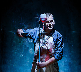 Image showing Bloody Halloween theme: crazy killer as butcher with saw