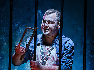 Image showing Bloody Halloween theme: crazy killer as butcher with saw