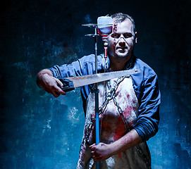 Image showing Bloody Halloween theme: crazy killer as butcher with saw